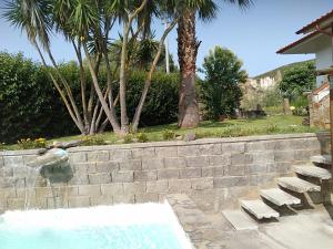 a swimming pool with chairs and a retaining wall at Casa Luciano 