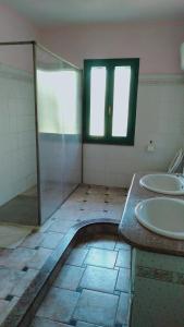 un bagno con due lavandini e una doccia in vetro di Casa Luciano 