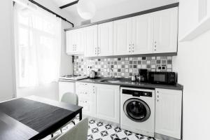 una cucina con lavatrice e tavolo di Modern Flat 5 min to Galata Tower in Istiklal Ave a Istanbul