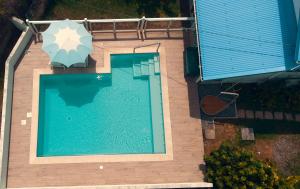 widok na basen z parasolem w obiekcie Villa Stone pour 8 personnes, piscine chauffée, accès PMR, 5 étoiles w mieście Sainte-Luce