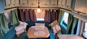 a small room with a table in the back of a bus at Przyczepa Mumbai in Jastarnia +51 photos