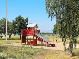 een speeltuin met een glijbaan in een park bij Holiday home RONNEBY X in Ronneby