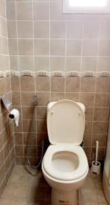 La salle de bains est pourvue de toilettes et d'un rouleau de papier toilette. dans l'établissement شاليه على البحر UAE, Abu Dhabi, à Baţīn