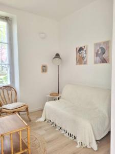 - une chambre blanche avec un lit et une chaise dans l'établissement Cocoon Urbain Nantais, à Nantes