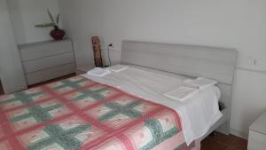 a bedroom with a bed with a white and green comforter at Dimora Chiara 