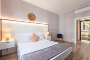 ein Schlafzimmer mit einem großen weißen Bett und einem Fenster in der Unterkunft Milan Retreats Duomo in Mailand
