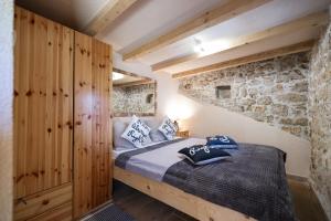 a bedroom with a bed and a stone wall at Holiday house Manuela in Kruševo +40 photos