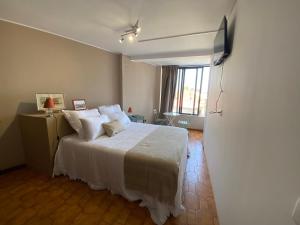 a bedroom with a large bed with white sheets at Jardim do Morro Places in Vila Nova de Gaia