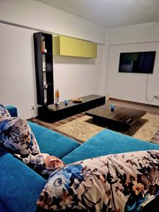 Cozy appartment in the center في تارغوفيست: غرفة معيشة مع أريكة زرقاء وطاولة