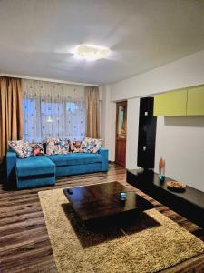 a living room with a blue couch and a table at Cozy appartment in the center in Târgovişte