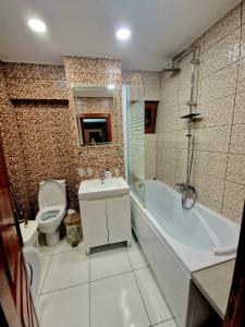Cozy appartment in the center في تارغوفيست: حمام مع مرحاض وحوض استحمام ومغسلة