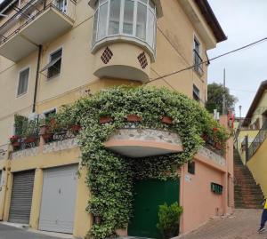 a building with a green door and a balcony at La casa dei gelsomini in Alassio