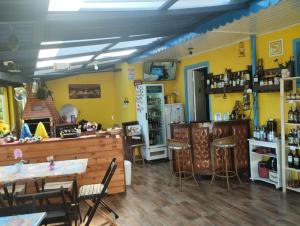 a restaurant with yellow walls and tables and chairs at Pousada Cantinho da Mi & Teco in Campos do Jordão