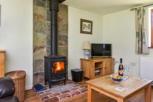 a living room with a wood stove in a room at Taylors Copse Cottage by Inspire Stays in Petersfield