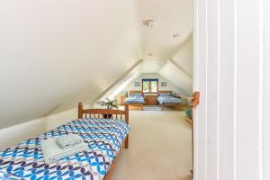 a attic bedroom with a bed and a staircase at Taylors Copse Cottage by Inspire Stays in Petersfield