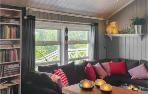 ein Wohnzimmer mit einem schwarzen Sofa und einem Fenster in der Unterkunft Gorgeous Home In Berger With House Sea View in Svelvik