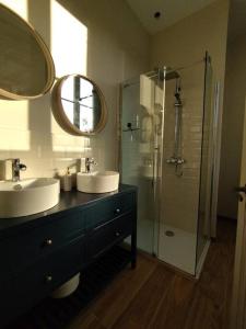 ein Badezimmer mit zwei Waschbecken und einer Glasdusche in der Unterkunft Domaine de Beaucamp in Châtelraould-Saint-Louvent