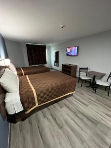 pokój hotelowy z łóżkiem, stołem i krzesłami w obiekcie Relax Inn Channelview w mieście Channelview