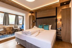 a bedroom with a large white bed in a room at Hotel Schlosshof in Ischgl