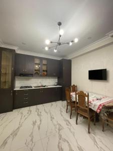 eine Küche mit einem Tisch und Stühlen sowie einem TV in der Unterkunft Green house - Apartment 1g - 17 in Rustawi
