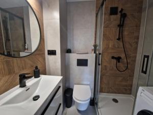 a bathroom with a sink and a shower and a toilet at Apartament Lato Nad Morzem in Gdańsk