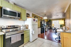 a kitchen with green cabinets and a white refrigerator at Houston Vacation Rental about 10 Mi to Downtown in Houston
