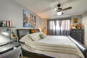 a bedroom with a bed with a ceiling fan and a desk at Houston Vacation Rental about 10 Mi to Downtown in Houston