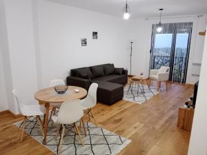 sala de estar con sofá negro, mesa y sillas en Panorama 17, en Vrnjačka Banja