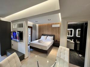 een slaapkamer met een bed, een tv en een bad bij InLofts in Afitos