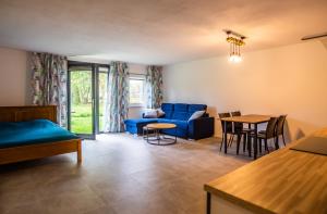 a living room with a blue couch and a table at Domki w górach in Międzylesie