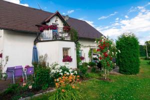 Casa blanca con balcón lleno de flores en Vila Marcelka, en Broumov