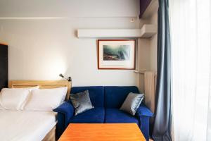 a room with a blue couch and a bed at Alpha 1 in Athens