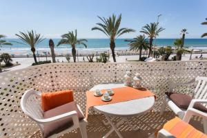 a patio with a table and chairs and the beach at Liliane Apartment in Sitges