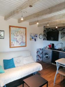 sala de estar con sofá blanco y cocina en Le Garni Vendémiaire en Vesoul