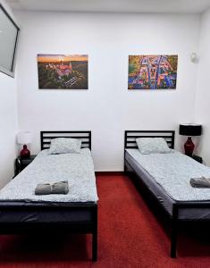 two beds in a room with paintings on the wall at Noclegi Wałbrzych Centrum in Wałbrzych