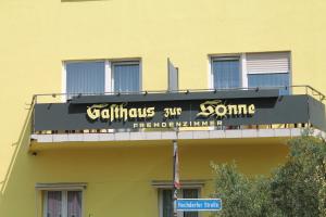 una señal en el lateral de un edificio amarillo en Gasthaus Zur Sonne, en Freiburg im Breisgau