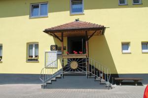un bâtiment jaune avec un escalier menant à une porte dans l'établissement Gasthaus Zur Sonne, à Fribourg-en-Brisgau
