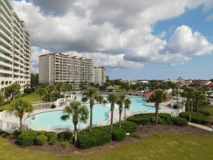 Una gran piscina con palmeras y edificios. en Lovely Studio - Yacht Club, en Myrtle Beach
