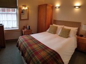 a bedroom with a large white bed with two pillows at The Old Cannon Brewery in Bury Saint Edmunds