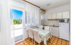 une cuisine avec une table et des chaises ainsi qu'une fenêtre dans l'établissement Beautiful Apartment In Trogir With Kitchen, à Trogir