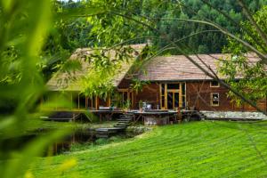 uma casa de madeira com uma doca ao lado de um rio em Crossline Lodge em Gheorgheni