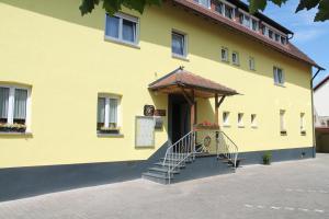 a yellow building with a staircase in front of it at Gasthaus Zur Sonne in Freiburg im Breisgau