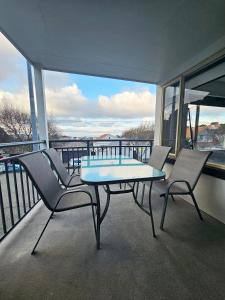 a table and two chairs on a balcony with a view at Light & Airy Heart of Central Kelburn! in Wellington