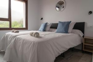 a large white bed with a dog laying on it at La Mina de Vega in Berbes