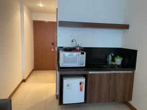 a small kitchen with a microwave and a refrigerator at A309 Flat aconchegante - Asa Norte in Brasilia