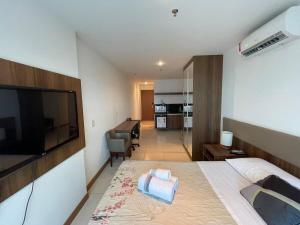 a bedroom with a bed with a television and a desk at A309 Flat aconchegante - Asa Norte in Brasilia
