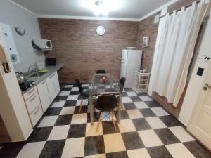 uma cozinha com uma mesa e um piso em xadrez em Pequeña Allegra em San Juan