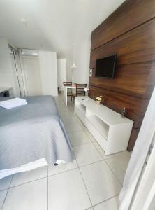 a bedroom with a bed and a tv on a wall at F1115 FD Flat em área central de Brasília - Asa Norte in Brasilia