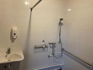 La salle de bains est pourvue d'une douche et d'un lavabo. dans l'établissement Toila Sadamakapteni tuba, à Toila