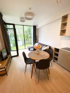 uma sala de estar com mesa e cadeiras em Apartment-Pine Forest Birštonas em Birstonas